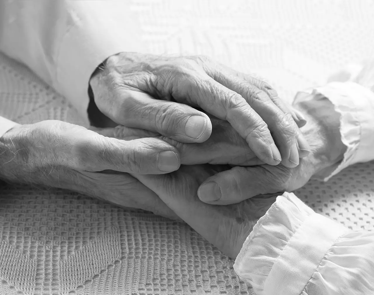 An elderly couple holding hands