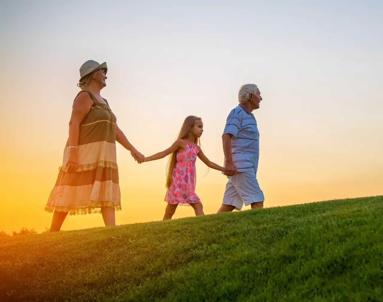 A young girl walking with her grandparents